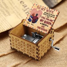 an open wooden music box with a card inside