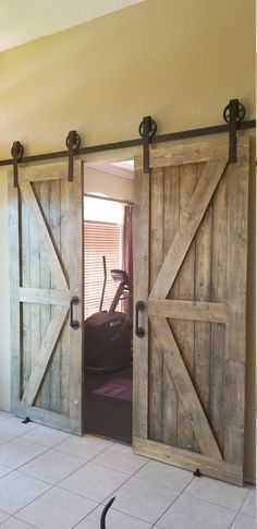 an open sliding barn door in a home with tile flooring and beige walls,