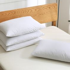 three pillows stacked on top of each other on a bed