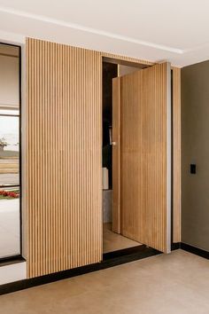 an open door in a room with wooden slats on the walls and flooring