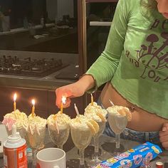 a woman is lighting candles on some desserts