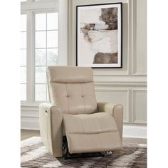 the reclining chair is in front of a window with a framed painting on it