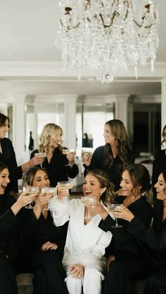 a group of women sitting next to each other holding wine glasses