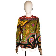 OlIVIER DE VERLON sweater. Vintage from the 1970s. wool fabric. long sleeve pullover. African-inspired pattern. Geometric pattern. Hot colors: green, red, yellow, and black. Blouse/shirt without pockets or buttons. Made in France. Size on label: 2 Approximate size: L Measurements: Shoulder to shoulder: 40 cm (15.5 inches) Bust: 96 cm (38.0 inches) in circumference (48 cm (19.0 inches) when measured in plane) Waist: 84 cm (33.0 inches) circumference (42 cm (16.5 inches) when measured in plane) Le Multicolor Long Sleeve Sweater With Geometric Pattern, Multicolor Geometric Pattern Long Sleeve Sweater, Retro Long Sleeve Sweater With Graphic Print, Multicolor Wool Tops For Fall, Multicolor Wool Top For Fall, Retro Tops With Colorful Pattern For Fall, Retro Colorful Patterned Tops For Fall, Retro Wool Crew Neck Top, Vintage Wool Long Sleeve Tops