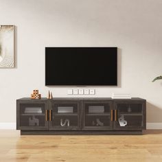 a flat screen tv mounted to the side of a wooden entertainment center in a living room