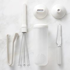 an assortment of kitchen utensils on a white surface