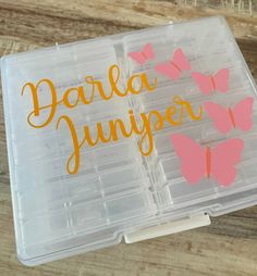 a plastic box with some pink and orange butterflies in it that says darla junior