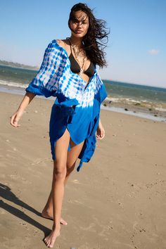 Tie-dye kimono. Open front. Short kimono sleeves. Thigh length. Loose fit. 100% Rayon. Imported. Designed in LA. Model wears size S. Blue Wrap Summer Cover-up, Blue Wrap Kimono For Beachwear, Blue Wrap Kimono For Summer, Blue Cover-up With Kimono Sleeves For Summer, Blue Kaftan With Kimono Sleeves For Beach Season, Blue Open Front Kaftan For Vacation, Blue Wrap Kaftan For Festivals, Long Tie Dye Kimono For The Beach, Summer Indigo Long Sleeve Kimono