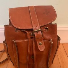 Great Condition. Lots Of Pockets. Hardly Used. Original Tags Available. Brown Distressed Italian Leather Bag Adjustable Shoulder Straps, Internal And External Pockets, Clasp Closure Interior: 1 Zip Pocket And 2 Slip Pockets, Lined Exterior: Front Flap With Buckle Detail, Front Pocket, 2 Slip Pockets On Sides Bag Measurements - H 10 X W 8 X B 5 Cognac Backpack With Adjustable Strap, Cognac Backpack With Adjustable Strap For Daily Use, Casual Brown Leather Backpack With Leather Lining, Casual Brown Backpack With Removable Pouch, Casual Brown Bucket Backpack, Brown Flap Backpack With Adjustable Strap, Brown Backpack With Adjustable Strap And Flap, Casual Brown Satchel With Leather Backing, Brown Leather Flap Backpack