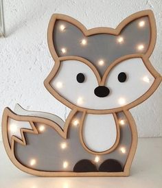 a wooden light up fox sitting on top of a table next to a white wall