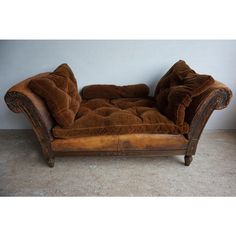 a brown couch sitting on top of a cement floor