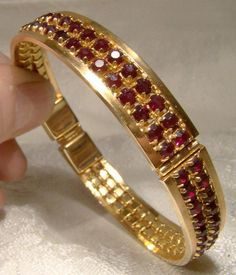 A double row garnet red rhinestone hinged bangle bracelet from the 1960s.  This vintage rigid round gold plated bracelet has an interior measurement of 2-1/2" across and it is 3/8" wide. All of the deep red rhinestones sparkle brilliantly and all are claw-set. The push-in clasp has a red baguette rhinestone.  This well made bracelet is unsigned but of good quality.  Please note that the interior measurement is 2-3/8" at the inner clasp section as the mechanism sits inside the bangle. It is in excellent condition with no chips, cracks, dents, bends, corrosion, losses, damage or repairs. Please note that the rhinestones are a deeper Bohemian garnet red in real life.  Items are vintage or antique and have signs of use and patina as would be expected. Tracked packet to anywhere in the U.S. is Net Design, Bangles Gold, Garnet Red, Bangles Design, Beads Jewellery, Stone Bangle, Bangles Jewelry Designs, Diamond Jewelry Designs, Gold Bangles Design