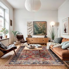 a living room filled with furniture and a large painting on the wall above it's coffee table