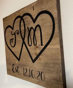 a wooden sign with two hearts on it