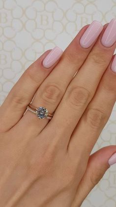 a woman's hand with pink manies and a ring on her left hand