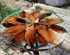 a glass table with wooden leaves on it