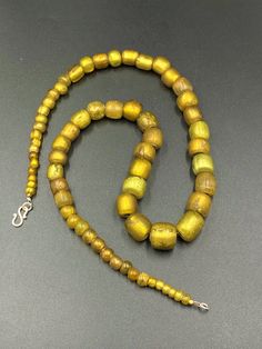 The beautiful Ancient Roman's time Glass beads The origin of this beads is central Asian countries very rare shape and rare color of this beads necklace Traditional Yellow Gemstone Beads Necklace, Amulet Necklaces With Large Oval Beads, Amber Necklace With Round Wooden Beads, Amulet Style Wooden Beaded Necklace, Amulet Style Necklace With Wooden Beads, Amulet Style Beaded Necklace With Round Wooden Beads, Amulet Necklace With Large Round Beads, Amulet Necklaces With Large Round Beads, Gold Amulet Necklace With Polished Beads