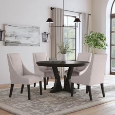 a dining room table and chairs with a rug on the floor in front of it