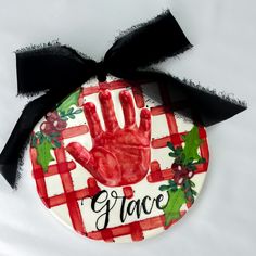 a ceramic ornament with a handprint on it and the word grace painted on it