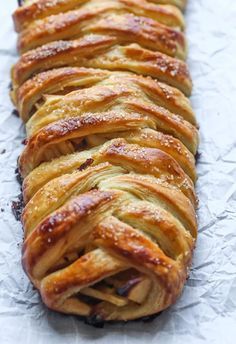 a long pastry is sitting on top of some wax paper and it looks like braided bread