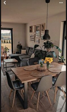 a living room filled with furniture and a wooden table in front of a large window