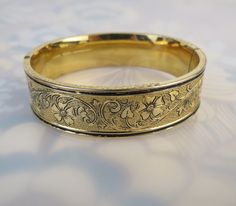 "The Binder Bros. Inc. (est. 1920 NY, NY) made this antique 10kt gold filled bangle with a lovely chased and engraved floral leaf vine design. Both sides of the form are covered with lots of detail and a patterned background. A lot of the original black enamel is present with some loss. This piece looks beautiful on its own, but would also be a fun stacking bangle. It has a working push button clasp. The original safety chain is missing so I have included a free 17 1/2 inch 12kt gold filled chai Rhodolite Garnet Ring, Patterned Background, Enamel Bangle, Victorian Gold, Vine Design, Stacked Bangles, Safety Chain, Platinum Ring, Garnet Rings