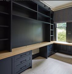 an empty room with black cabinets and drawers