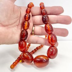 Vintage Art Deco Bakelite bead necklace. A beautiful graduating strand of chunky, oval orange / cherry Amber Bakelite beads. Circa 1930's. Great condition. Details -  Length - 27.5" Largest bead - 30 x 22mm Weight - 65 grams Along with vintage costume jewellery you will also find a huge collection of Uranium, Cadmium, Selenium and Spinel uv reactive jewellery. Please take a look at my other listings. Orange Necklace With Large Oval Beads, Orange Necklaces With Large Oval Beads, Amber Oval Beaded Necklaces For Jewelry Making, Amber Oval Beads Single Strand Necklace, Amber Oval Beads Necklace For Jewelry Making, Amber Single Strand Necklace With Oval Beads, Large Oval Orange Beads, Amber Beaded Necklace With Large Oval Beads, Amber Beaded Necklaces With Large Oval Beads