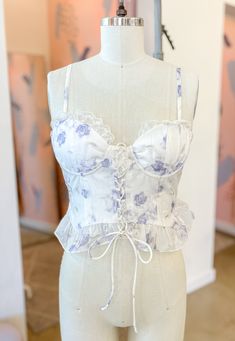 Add a touch of playfulness to your summer wardrobe with the Artemis Top. This soft, feminine top features delicate ruffles and sweet lacing detail. The comfortable and stretchy back ensures a perfect fit. Adjustable spaghetti straps Adjustable lacing at front Elastic shirring at back Summer Cotton Corset With Built-in Bra, Feminine Fitted Camisole With Built-in Bra, Lace Ruffled Camisole Tank Top, Lace Ruffle Camisole Tank Top, Summer Stretch Chic Corset, Chic Stretch Summer Corset, Chic Summer Stretch Corset, Lace Ruffled Cami Tank Top, Lace Ruffle Cami Tank Top