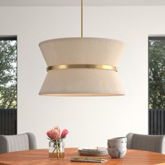 a dining room table and chairs with a light fixture hanging over it