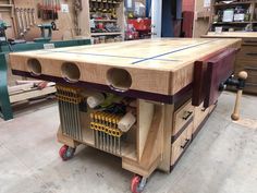 a workbench made out of wood with tools on it's wheels in a shop