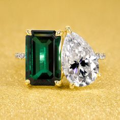 an emerald and diamond ring on a gold background