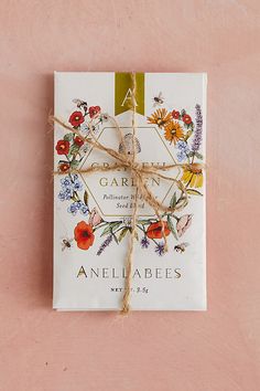 a book tied up to a pink wall with flowers on the front and back cover