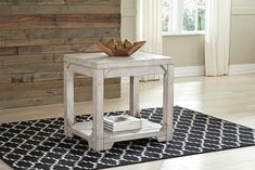 a white table sitting on top of a rug in front of a wooden paneled wall