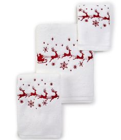 three white towels with red santa's sleigh and stars on the side