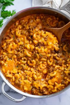 a pot filled with macaroni and cheese on top of a table