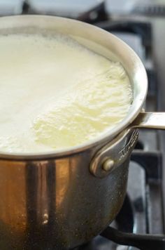 a pot filled with liquid sitting on top of a stove next to a burner