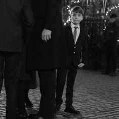 two men and a young boy standing in front of christmas lights