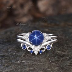 a close up of a ring with a blue stone in the center on a rock