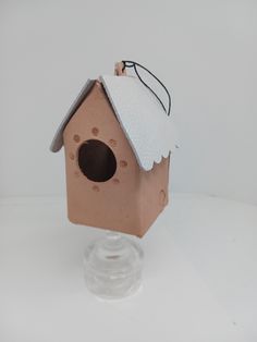 a small birdhouse with a white top on it's roof and a clear base