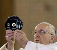 a man holding up a cd in front of his face with the word saint peter on it