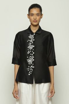 Black shirt with mother of pearl embellishment. - Aza Fashions Elegant Embellished Summer Shirt, Elegant Black Embellished Shirt, Elegant Embellished Spring Shirt, Spring Workwear Shirt Embellished, Designer Tops With Embellished Collar For Work, Designer Silk Tops With Buttons, Elegant Embroidered Shirt For Festive Occasions, Elegant Festive Embroidered Shirt, Embellished Fitted Shirt For Workwear