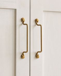 an image of a door handle that is on the side of a white door with gold handles