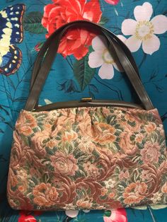 "Vintage 60s brown tapestry purse has beautiful rose pattern in mocha brown, peach, green and ivory. Purse has faux leather handles and trim. Purse is lined with vinyl and has a clear plastic attached coin purse which would also be perfect for ID card. Brass tone metal clasp shows wear otherwise purse is in excellent condition. No Label Purse measures 13\" side to side, @ 9\" tall and 4\" across bottom. Strap is 17\" across." Vintage Tapestry Bag For Everyday, Vintage Beige Tapestry Bag, Vintage Tapestry Tote Bag, Retro Rectangular Tapestry Bags, Vintage Tapestry Bag With Detachable Handle, Vintage Brown Tapestry Satchel, Vintage Tapestry Satchel With Top Handle, Vintage Tapestry Satchel With Top Carry Handle, Vintage Satchel Shoulder Bag With Rolled Handles