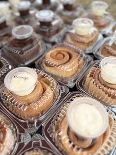 several cupcakes with icing in plastic containers