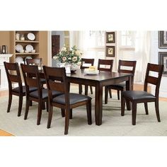 a dining room table and chairs in front of a fireplace