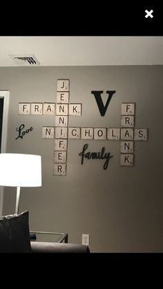 a living room wall with scrabble tiles on it and a lamp in the corner