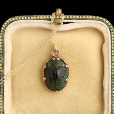 The Victorians were great fans of novelty jewelry. Ornaments of curiosity were designed with consideration for beauty and color, but also with the intent to amuse and delight the wearer. Such eccentric styles include mounted hummingbird heads, tiny golden renderings of mice, and bejeweled flies, just to name a few. This scarab pendant would have been classed a “Cleopatra ornament” at the time it was made, though it bears little relation to the jewels of Ancient Egypt, and in fact, the beetles Antique Oval Necklaces With Charms, Antique Charm Necklaces For Collectors, Collectible Oval Pendant Charms Jewelry, Luxury Charms Necklace, Elegant Bronze Necklaces With Charms, Victorian Style Charms Jewelry For Formal Occasions, Victorian Charm Necklace For Formal Occasions, Victorian Style Formal Necklaces With Charms, Victorian Formal Charms Necklace