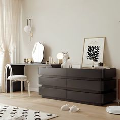 a living room with white walls and black furniture in the center, along with a rug on the floor