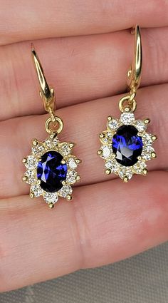 I purchased these wonderful earrings from an estate sale in the Middle East. Comprised of 14k solid, stamped gold, these lever back earrings are a royal delight similar to those worn by Princess Diana and Princess Kate. Each earring features one faceted oval medium dark blue synthetic (lab-created) high quality sapphire weighing 1.0 carats and measuring 7.0mm x 5.0mm x 3.40 mm deep (2.00 approximately total carat weight for both earrings). Each earring also features 10 round earth-mined brillian Formal Yellow Gold Lever Back Earrings, 14k Gold Lever Back Formal Earrings, Formal 14k Gold Lever Back Earrings, 14k Gold Lever Back Earrings For Formal Occasions, Yellow Gold Lever Back Earrings For Anniversary, 14k Gold Lever Back Drop Earrings, Gold Plated Lever Back Earrings For Anniversary, 14k Gold Lever Back Earrings For Anniversary, Yellow Gold Dangle Cluster Earrings For Anniversary